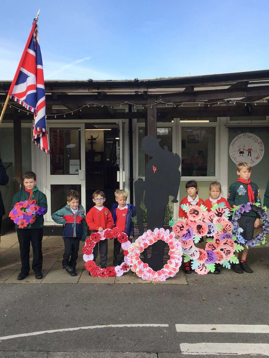 Children with poppy wreaths and flag