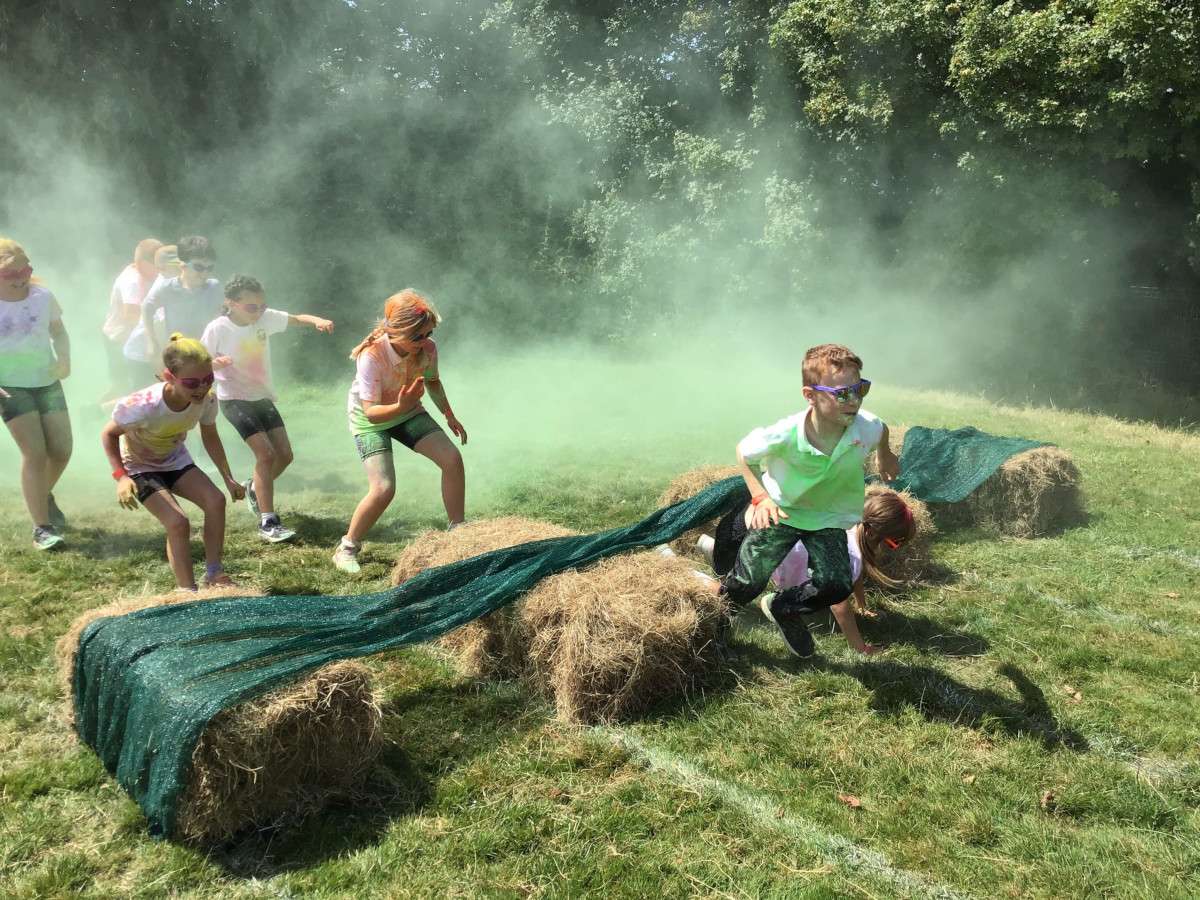Children running through a colourful obstacle course.