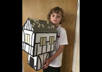 Child holding a model house.