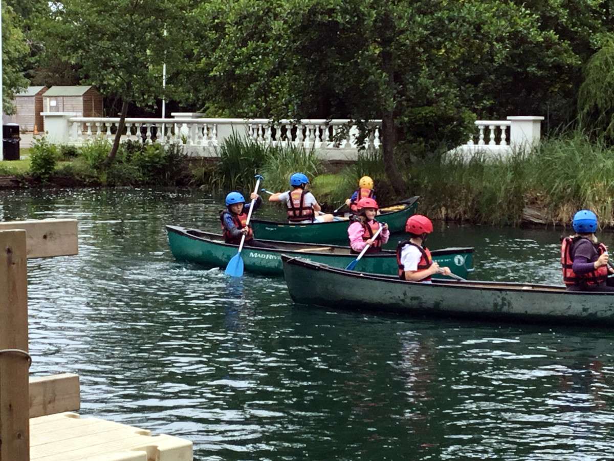 Children kayaking on a calm river.